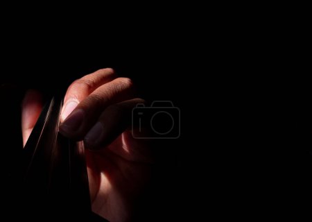 Foto de Mano sosteniendo violín con fondo negro y luz en los dedos - Imagen libre de derechos