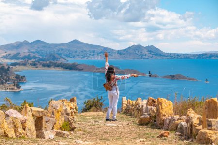 Foto de Latin woman on vacation taking selfie on Sun`s Island with Lake - Imagen libre de derechos