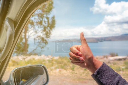 Foto de Woman showing thumbs up out the window of a car heading to her v - Imagen libre de derechos