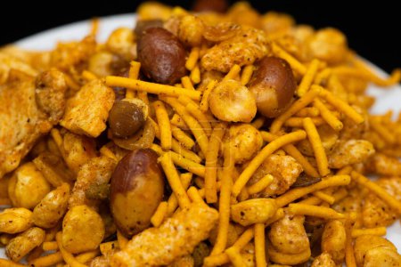 Hot spicy NavRatan mixture snacks in full-frame, made with, potato chips, peanuts, besan sev, red chili. Pile of Indian spicy snacks (Namkeen)