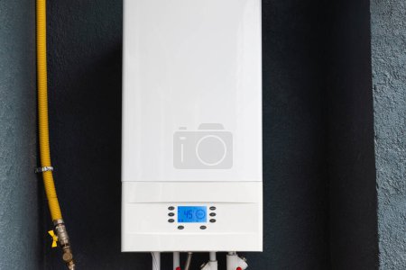 Téléchargez les photos : Double-circuit gas boiler for winter home heating and water heating installed on the balcony of modern house for autonomous heating - en image libre de droit