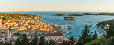 Panoramic skyline view of the old town of Hvar with turquoise water bay with yachts and islands in Dalmatia, Croatia and Adriatic sea. Summer vacation destination