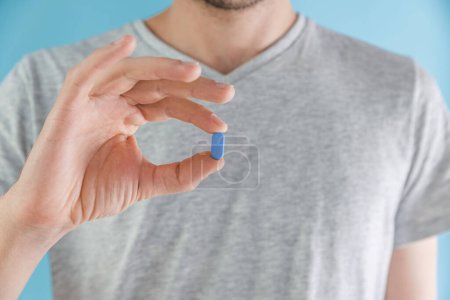 Téléchargez les photos : Homme tenant une pilule bleue PrEP. Prévention du VIH par prophylaxie pré-exposition. Santé des hommes. Concept de prévention du sida. - en image libre de droit