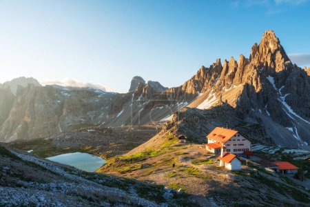 Lever du soleil de montagne à Tre Cime di Lavaredo Parc national et Rifugio Locatelli avec lac de montagne dans les Alpes Dolomites, Trentin-Haut-Adige, Italie. Paysage estival avec abri, lac et rochers, Sud
