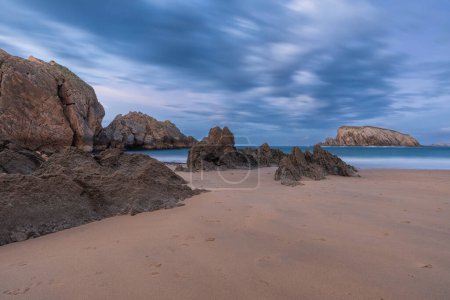 Playa de la Arnia à Santander, Cantabrie, Espagne du Nord avec des roches de flysch et plage de sable au crépuscule. Longue exposition. Destination de voyage populaire sur les vacances