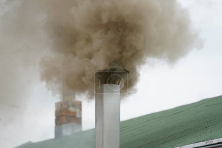 Rauch aus dem Schornstein. Luftverschmutzung. Rauch aus der Fabrik verschmutzt die Luft. Smog. Dunkler Rauch.