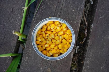 Foto de Pesca. Maíz en una lata en el muelle de madera. Cebo para pescar. Pesca de maíz. - Imagen libre de derechos