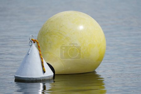 Foto de Boya amarilla en el agua. Señal de agua en el lago. Triángulo blanco en el lago. - Imagen libre de derechos