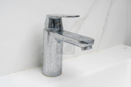 dirty water faucet covered in soap and limescale
