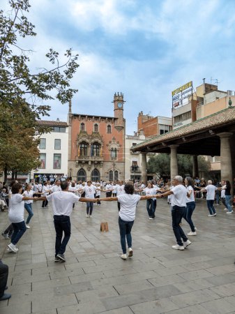 Photo for Granollers, Catalonia, Spain; 10,22,2022:Sardanista group from Granollers dancing in the porch square of Granollers with an audience in the background and an orchestra playing music - Royalty Free Image