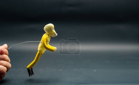 Photo for Stopmotion process of jumping. Jump start. Man's hand holding with an aluminum wire a figure made with yellow modeling paste starting the jumping process. The 12 principles of animation. - Royalty Free Image