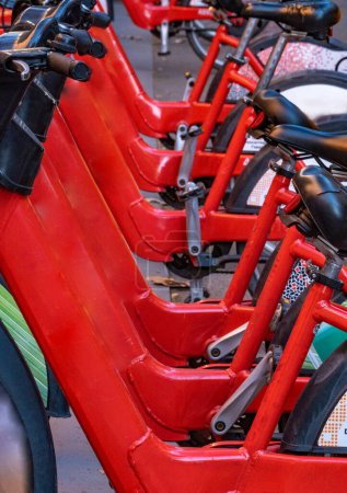 Photo for Detail of the handlebars and pedals of shared rental red bicycles parked in a row on a street in the city of Barcelona. - Royalty Free Image