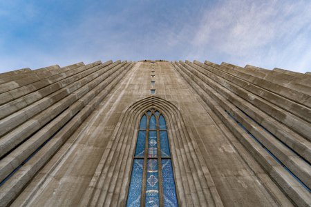Photo for Symmetrical view from below the minimalist architecture of the hallgrmskirkja cathedral based on the basalt formations of iceland illuminated by the first light of dawn. - Royalty Free Image