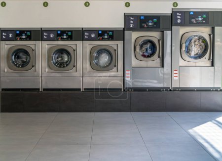 Foto de Lavadoras en una ciudad urbana lavandería para lavar y secar ropa, sábanas y manteles en una fila con las puertas cerradas - Imagen libre de derechos
