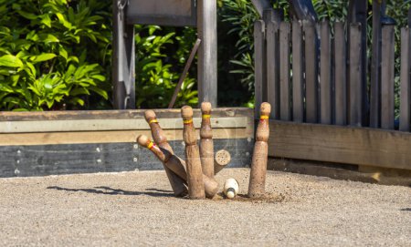 Photo for Moment of the impact of a small wooden skittle or bitllot against larger wooden skittles in the traditional game of Catalan skittles "Catalan Skittles", on the petanque court with a sand floor. - Royalty Free Image