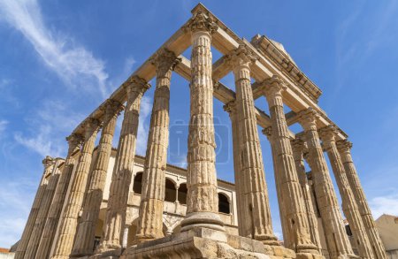 Photo for Triangular perspective view from below of the Roman Temple of Diana with well-preserved Corinthian style marble columns under a clear blue sky. Merida. Province of Badajoz, Extremadura, Spain. - Royalty Free Image