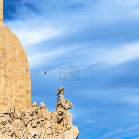 :Monument der Entdeckungen aus Kalkstein: Heinrich der Navigator hält ein Schiff in der Hand, das in Richtung Amerika blickt, während ein Passagierflugzeug kopfüber vorbeifliegt, um Lissabon zu landen.