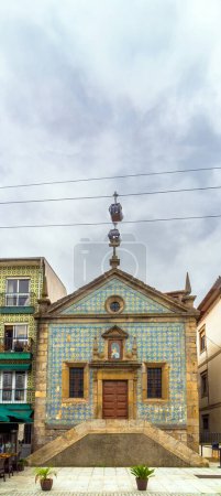 Dos góndolas del teleférico de Gaia pasan justo por encima de la cruz de la Capilla de Nuestra Señora de la Misericordia formando una línea perpendicular en Vila Nova de Gaia, decorada con azulejos. Porto Portugal.