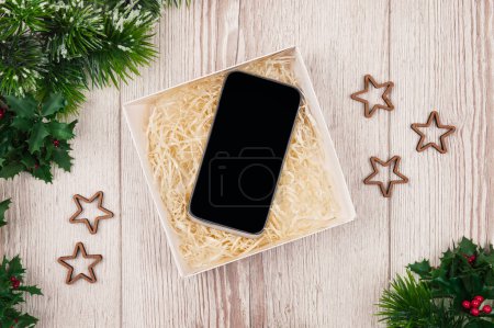 Téléchargez les photos : Achats de Noël en ligne. Mockup, smartphone écran blanc sur fond bois pour Noël et Nouvel An concept, Flat lay. vue du dessus, espace de copie . - en image libre de droit