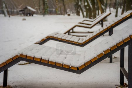 Photo for Snow-covered deck chairs on a winter beac - Royalty Free Image
