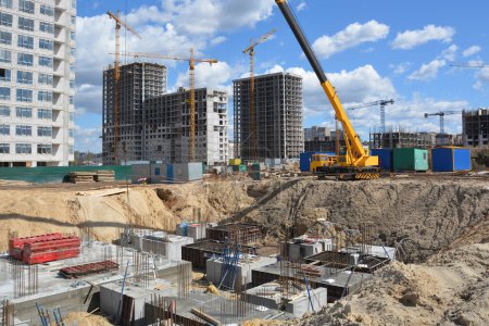Téléchargez les photos : Cranes and formwork and concrete foundations for the construction of a residential building - en image libre de droit