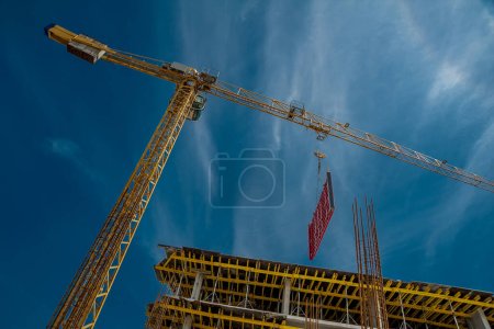 Photo for Wooden beams and a crane in a residential building on the background of the sky - Royalty Free Image