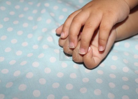 Les ongles des bébés de 11 mois sont longs, une petite partie des ongles est cassée et il y a de la saleté parce qu'ils n'ont pas été coupés.