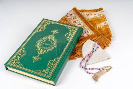 Quran,Men's skullcap ,muslim rosary beads seen on prayer mat.Ramadan Concept.