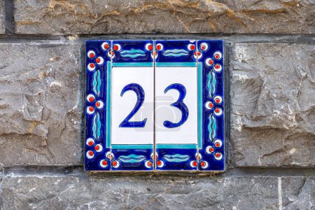 House number twenty three, on a decorative tile.