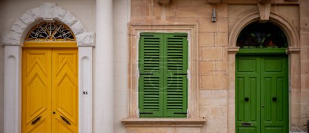 Photo for Yellow and green entrance doors in a residential building on the island of Malta. Colored architecture of Valletta. High quality photo - Royalty Free Image
