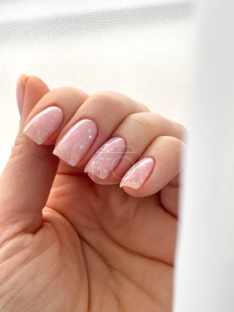 Photo for Womans hand with fresh manicure and delicate pink polish shape nail soft square. High quality photo - Royalty Free Image