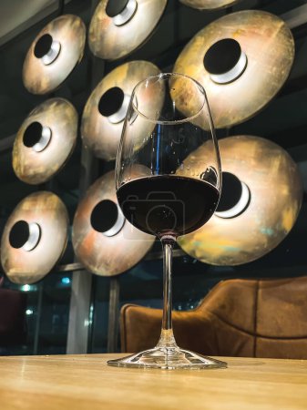 Photo for A glass of red wine against the background of unusual lamps. nice evening with a glass of wine. High quality photo - Royalty Free Image