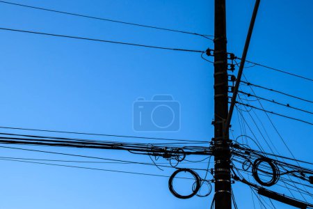 Photo for Many wires attached to the electric pole, the chaos of cables and wires on an electric pole, blue sky background, technological combination concept in Brazil - Royalty Free Image