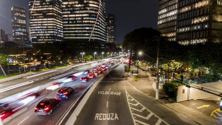 Photo for Sao Paulo, Brazil, September 22, 2023. View of commercial offices buildings and traffic jam on Juscelino Kubitschek Avenue, at night in the south side of Sao Paulo, city - Royalty Free Image