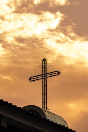 Foto de Cruz sobre una iglesia católica, con un cielo al atardecer en Brasil - Imagen libre de derechos