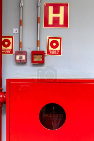 Detalle de una boca de incendios y alarma para la extinción y prevención de incendios, con señales adecuadas en portugués