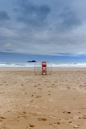 Chaise de sauveteur sur une plage vide par une journée nuageuse au Brésil