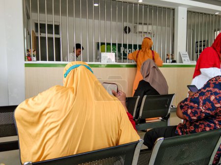 Téléchargez les photos : Probolinggo,Indonesia. Jan. 2023 : the atmosphere of the waiting room in the pawnshop office - en image libre de droit