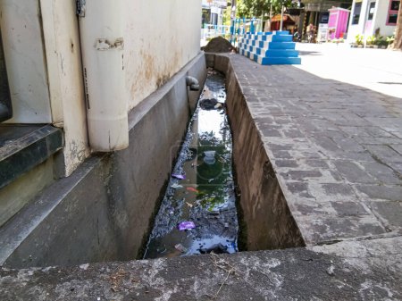 Téléchargez les photos : A water ditch in a housing estate that still has trash in it - en image libre de droit