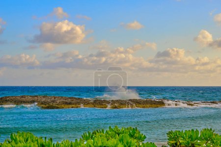 Téléchargez les photos : Une matinée de printemps partiellement nuageuse aux Bahamas alors que les vagues s'écrasent contre la paroi rocheuse - en image libre de droit