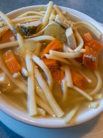 Foto de A bowl of Chicken Noodle Soup with noodles, chicken, carrots, and celery. - Imagen libre de derechos