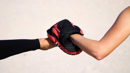 Photo for Close-up, female leg, a work in pairs, kicking a special glove. On a deserted beach, in summer, under a hot sun. Slow motion. High quality photo - Royalty Free Image
