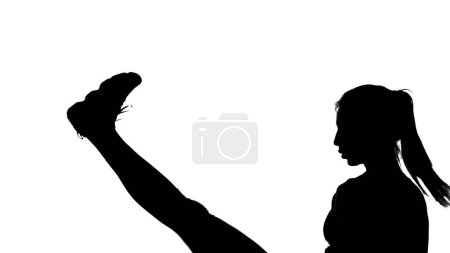 Téléchargez les photos : Sur fond blanc, une ombre, un contour noir d'une figure féminine faisant des mouvements de boxe, un combat avec une ombre, coups de pied, kickboxing, imitations de coups, techniques de combat,. Photo de haute qualité - en image libre de droit