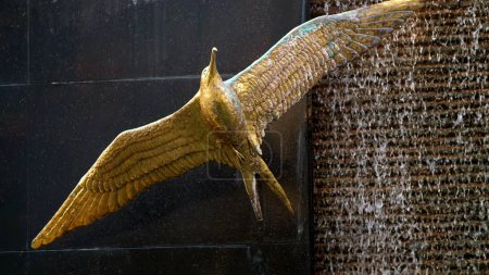 Photo for DUBAI, UNITED ARAB EMIRATES, UAE - NOVEMBER 20, 2017: hotel Sofitel The Palm. figure, statue of golden bird against the background of a waterfall fountain. High quality photo - Royalty Free Image