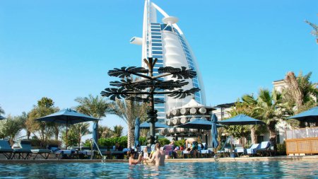 Photo for DUBAI, UNITED ARAB EMIRATES, UAE - NOVEMBER 20, 2017: Hotel JUMEIRAH AL NASEEM , near Burj al Arab. family vacation with little babies, relax near swimming pool. ,people play, swim in pool water. High - Royalty Free Image
