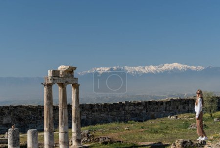 Photo for Woman at Roman ruins with snow-capped mountain peaks in the background in Turkey - Royalty Free Image