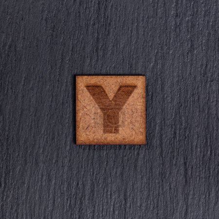 Photo for Capital Letter In Square Wooden Tiles - Letter Y, On Black Stone Background. - Royalty Free Image