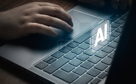 Foto de Woman using laptop with AI hologram interface. Concept of artificial intelligence use analytics, automation, and autonomous brain. - Imagen libre de derechos