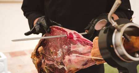 Photo for Banner of professional ham carver cutting cured ham slices. Spanish iberian ham. - Royalty Free Image
