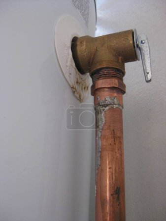 Foto de Copper Pipe with Fitting on Wall . High quality photo - Imagen libre de derechos